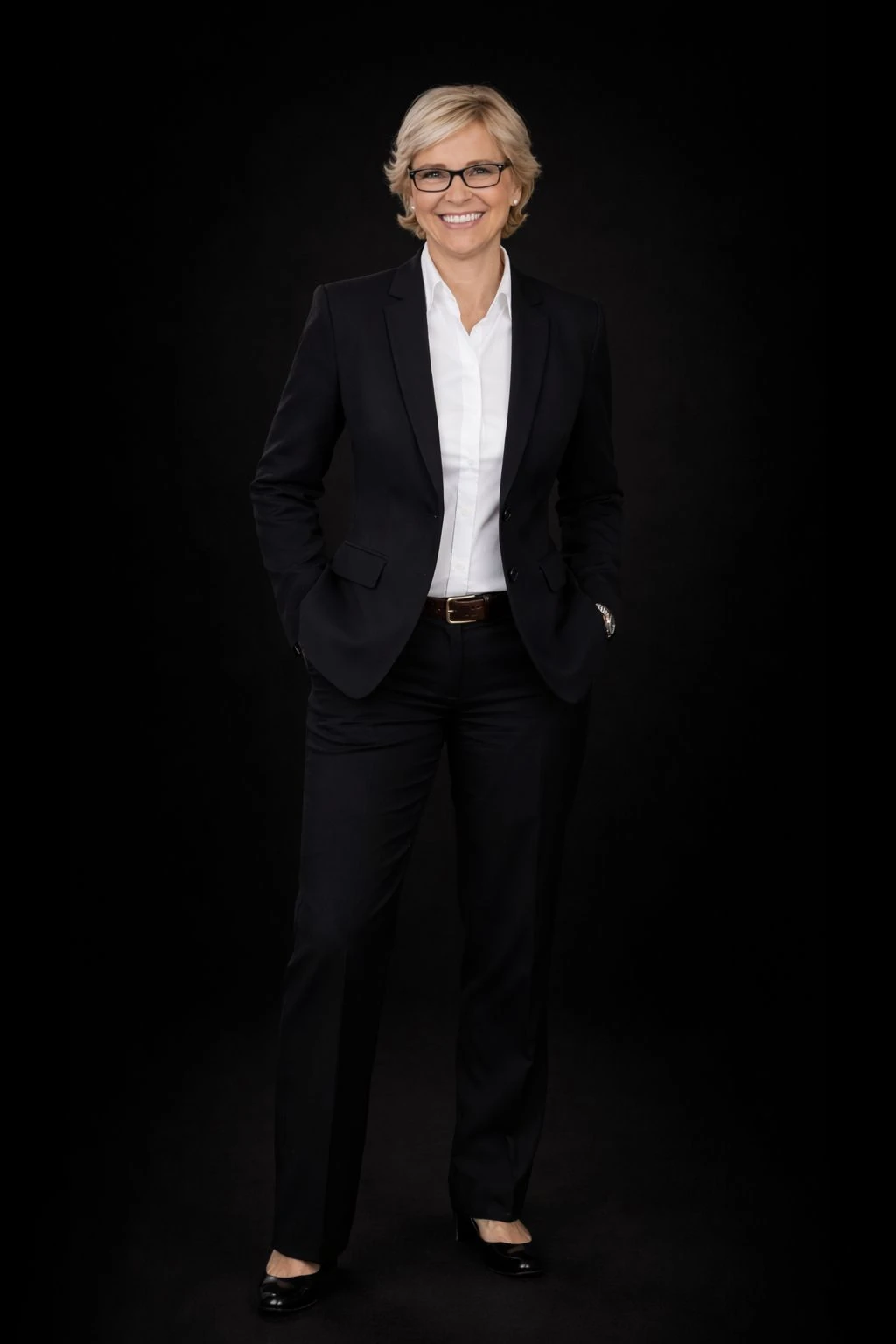 Ganzkörperporträt von Elke Klöfer im dunklen Business-Anzug.
